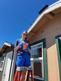 Stoel Rives volunteer painting trim on a Tiny House at the Hope Factory